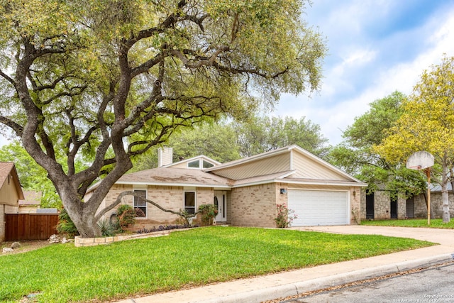 view of front of house featuring driveway, a front yard, fence, brick siding, and a garage