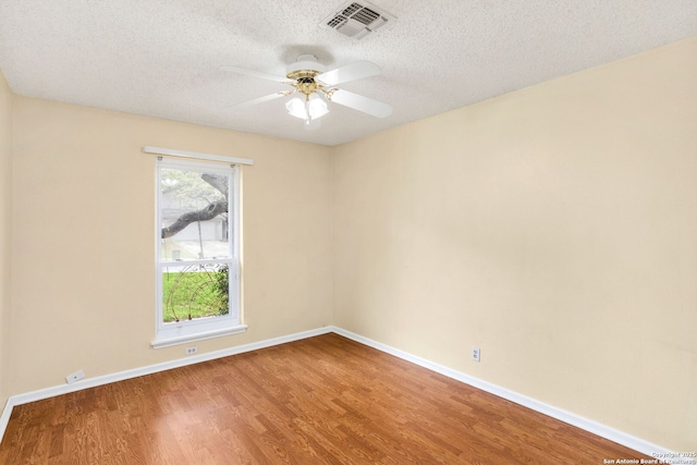 empty room with a ceiling fan, wood finished floors, baseboards, and visible vents