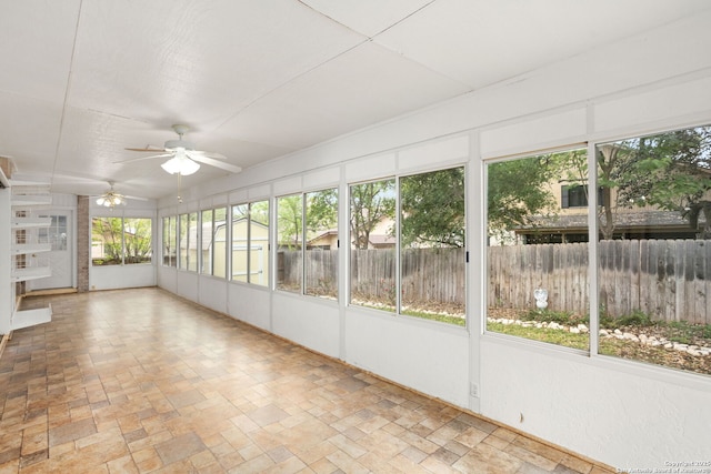 unfurnished sunroom featuring a ceiling fan