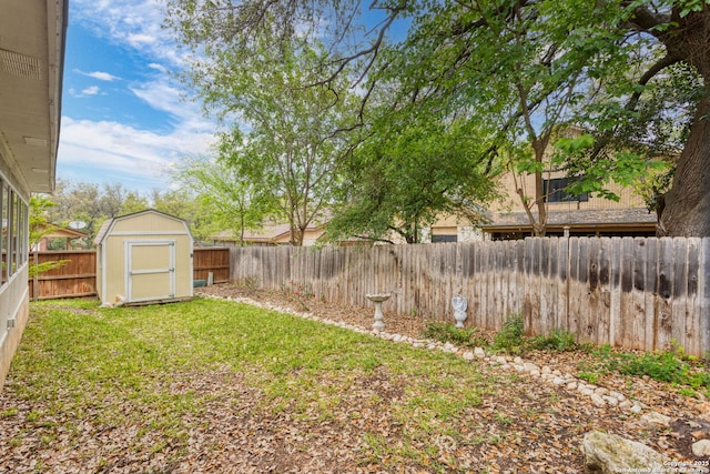 view of yard featuring a fenced backyard, an outdoor structure, and a storage shed