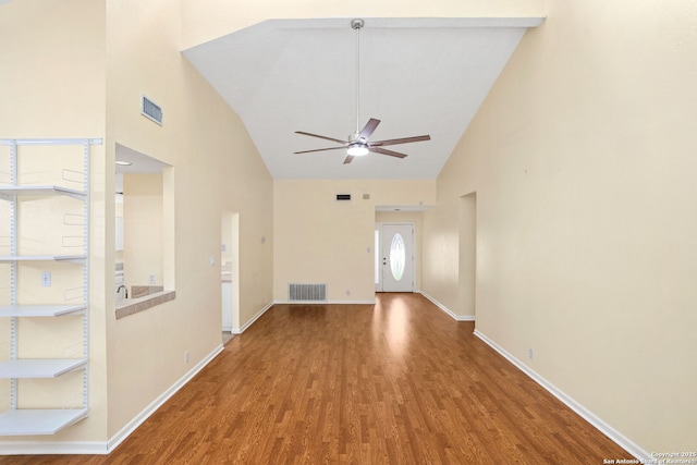 unfurnished living room with a ceiling fan, high vaulted ceiling, wood finished floors, and visible vents