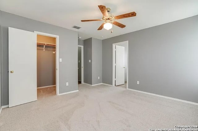 San Antonio, TX 78245 - unfurnished bedroom featuring a ceiling fan, light carpet, a walk in closet, baseboards, and visible vents