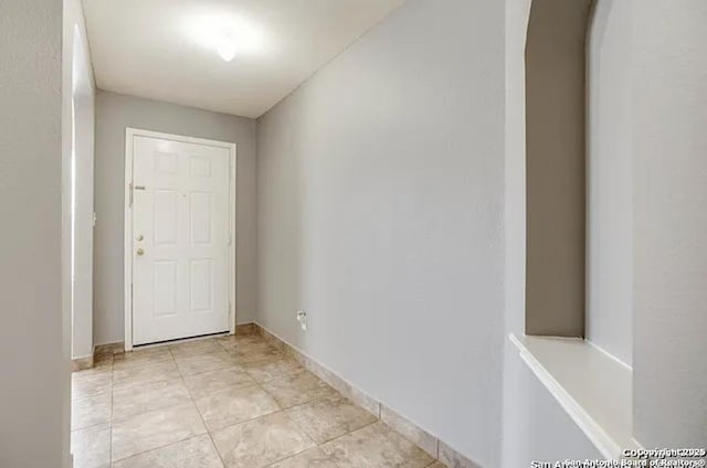 San Antonio, TX 78245 - unfurnished room featuring baseboards, arched walkways, and light tile patterned floors