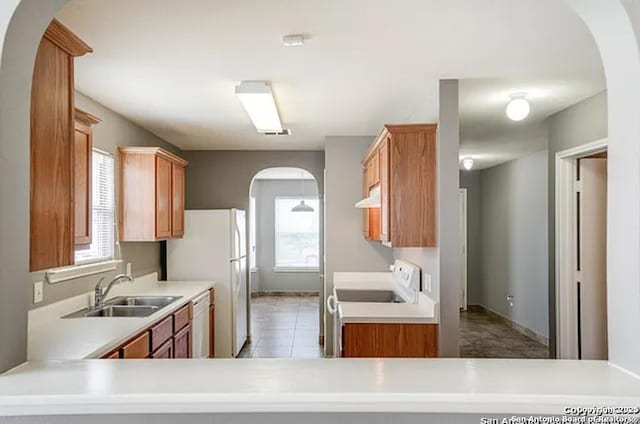 San Antonio, TX 78245 - kitchen featuring range, light countertops, arched walkways, under cabinet range hood, and a sink