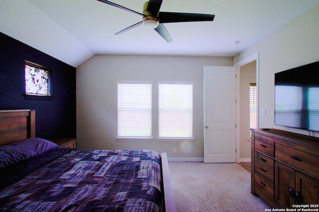 bedroom with light colored carpet, vaulted ceiling, baseboards, and a ceiling fan