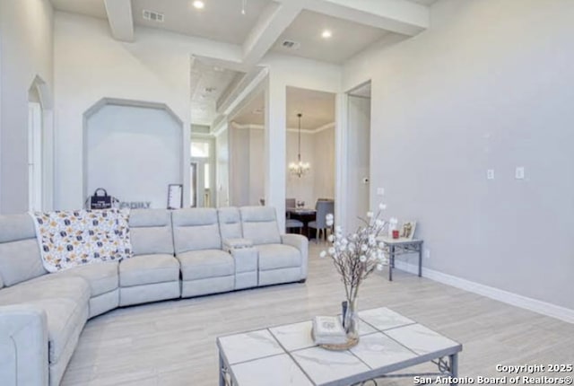 living area featuring an inviting chandelier, beam ceiling, visible vents, and light wood-style floors