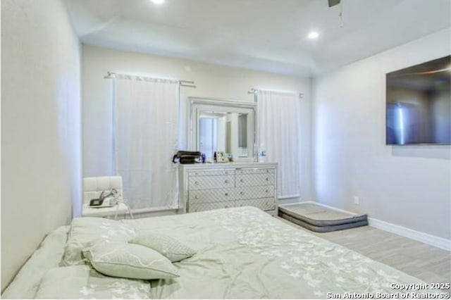 bedroom with recessed lighting, wood finished floors, and baseboards