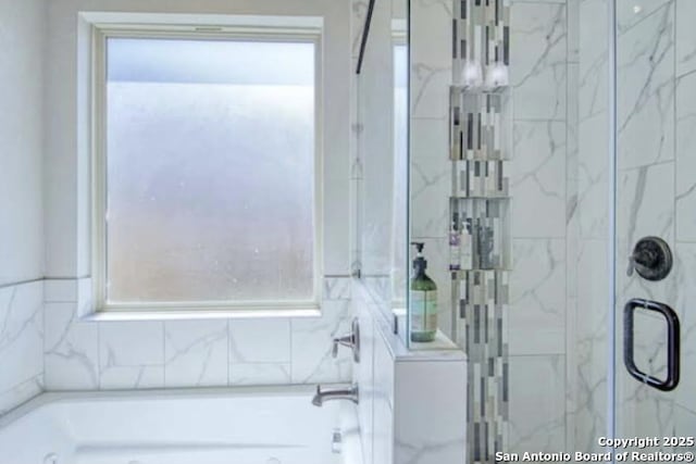 full bathroom featuring a bath and a stall shower