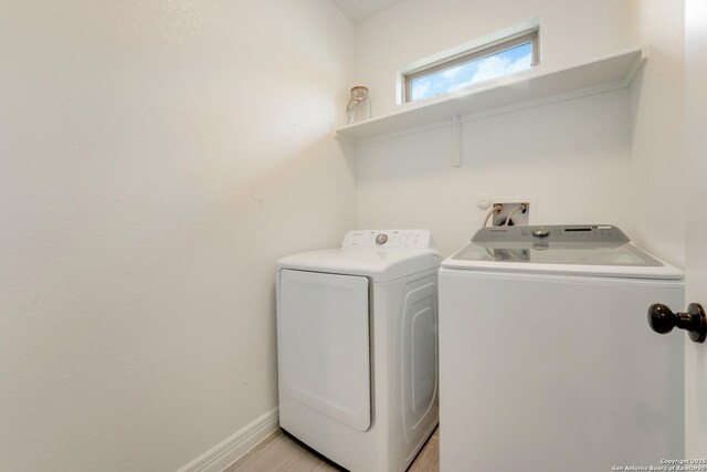 laundry area with washing machine and dryer, baseboards, and laundry area