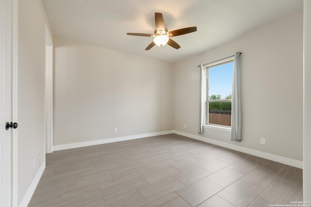 empty room with baseboards and a ceiling fan