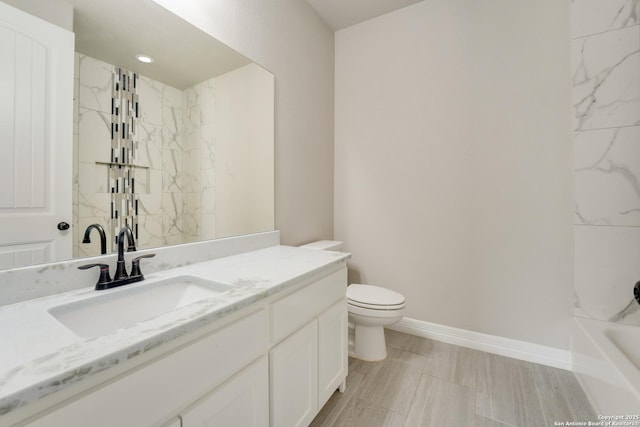 bathroom with baseboards, vanity, and toilet