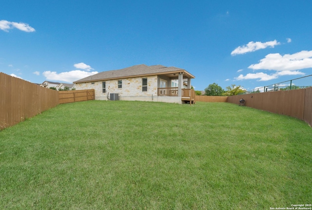 back of house featuring a yard, central AC, and a fenced backyard