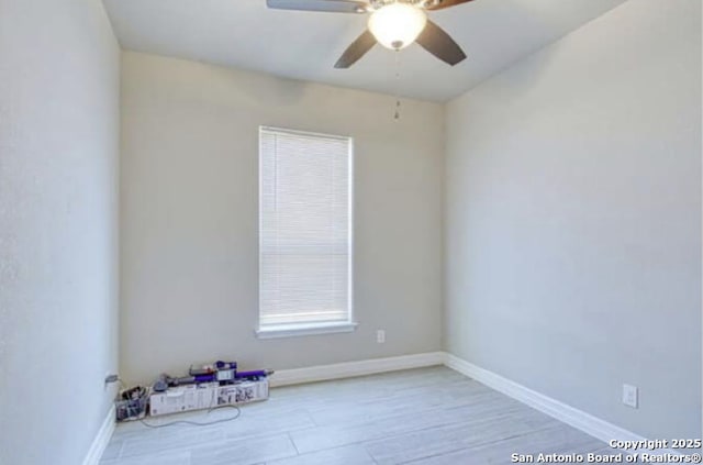 empty room featuring ceiling fan and baseboards