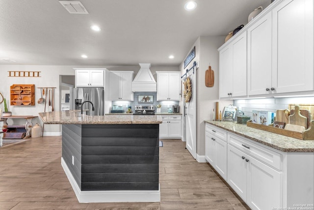 kitchen with visible vents, decorative backsplash, appliances with stainless steel finishes, and light wood-style floors
