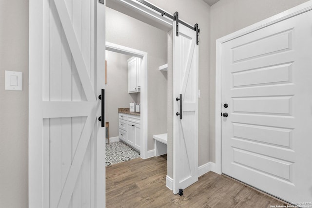 interior space with baseboards, vanity, and wood finished floors