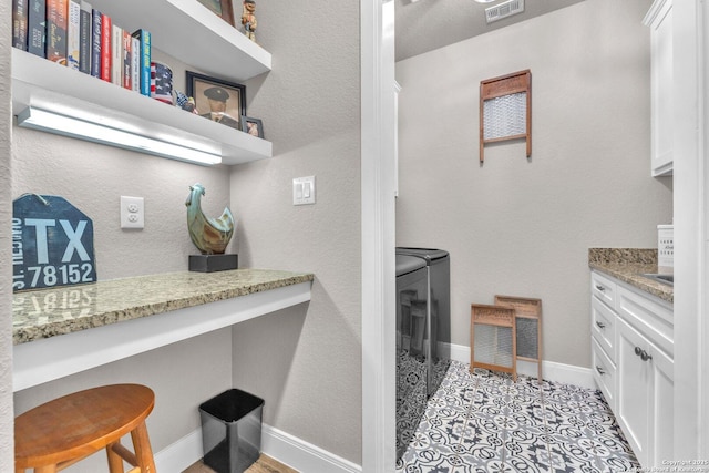 bathroom featuring visible vents, baseboards, washing machine and dryer, and vanity