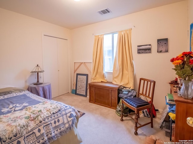 carpeted bedroom featuring visible vents and a closet