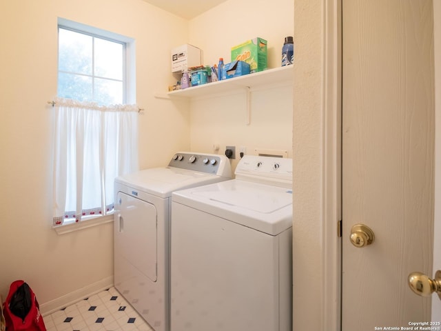 clothes washing area featuring plenty of natural light, independent washer and dryer, laundry area, and baseboards