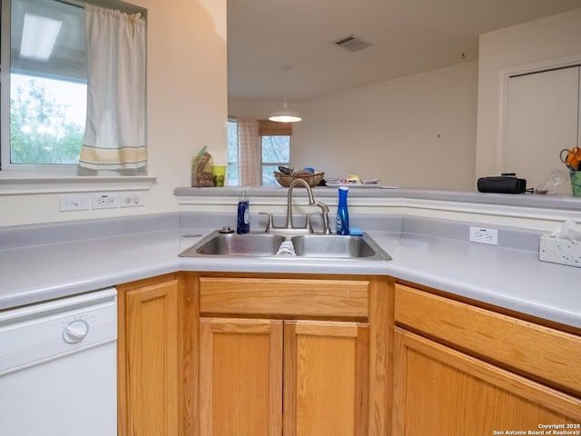 kitchen with a sink, visible vents, light countertops, and dishwasher