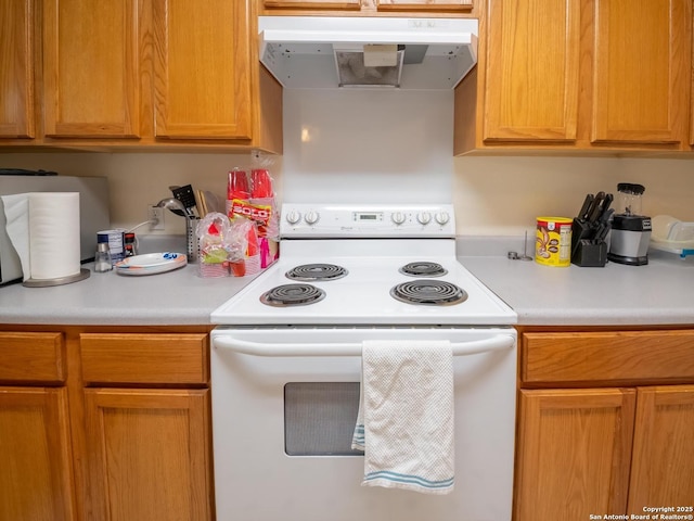 kitchen featuring white range with electric stovetop, light countertops, and under cabinet range hood