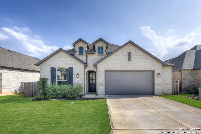 french country inspired facade featuring fence, a garage, brick siding, a front lawn, and driveway