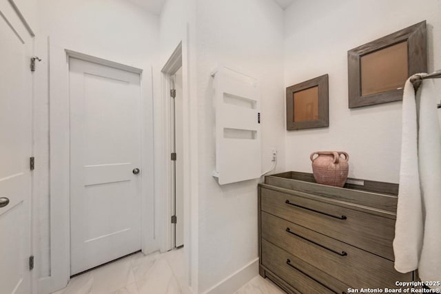 hall with marble finish floor and baseboards