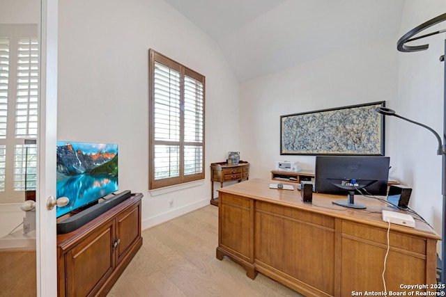 office space with baseboards, lofted ceiling, and light wood-type flooring