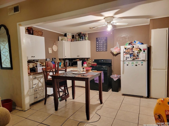 4831 Hemphill Dr, San Antonio, TX 78228 - kitchen featuring visible vents, white cabinets, freestanding refrigerator, crown molding, and black gas range oven