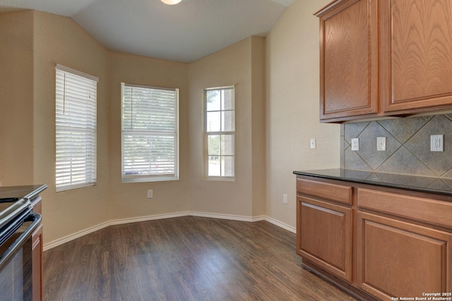 7614 Copper Dawn, Converse, TX 78109 - kitchen featuring dark wood finished floors, tasteful backsplash, dark countertops, stove, and baseboards