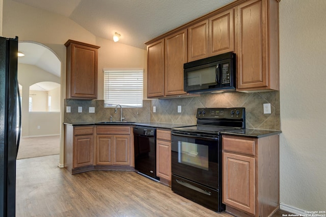7614 Copper Dawn, Converse, TX 78109 - kitchen featuring black appliances, vaulted ceiling, a sink, dark countertops, and decorative backsplash