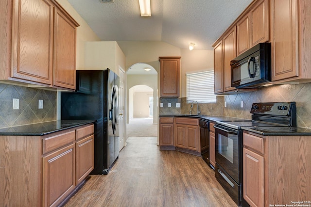 7614 Copper Dawn, Converse, TX 78109 - kitchen with black appliances, a sink, vaulted ceiling, arched walkways, and light wood finished floors