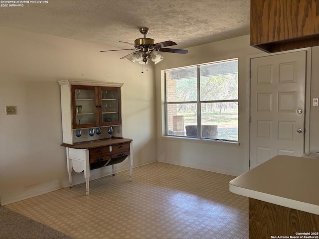 2501 Fischer Store, Wimberley, TX 78676 - dining space with tile patterned floors, a ceiling fan, baseboards, and a textured ceiling