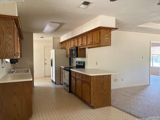 2501 Fischer Store, Wimberley, TX 78676 - kitchen with stainless steel range with electric stovetop, a sink, black microwave, brown cabinetry, and light colored carpet