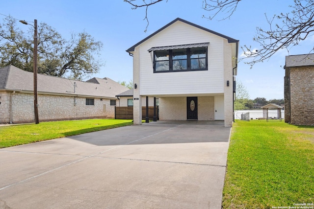 411 W Greenbriar Dr, Granite Shoals, TX 78654 - view of front of property with concrete driveway, a carport, fence, and a front lawn