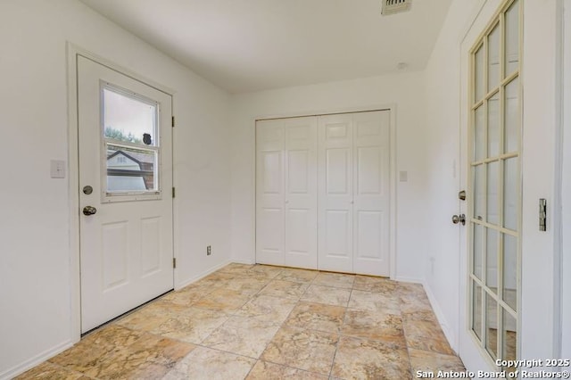 foyer entrance with baseboards and visible vents