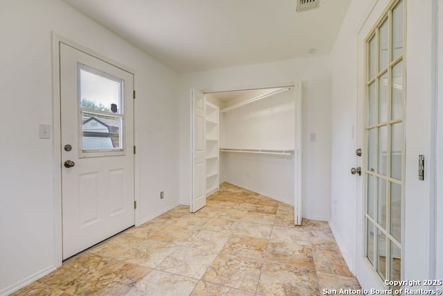 foyer entrance with baseboards and visible vents