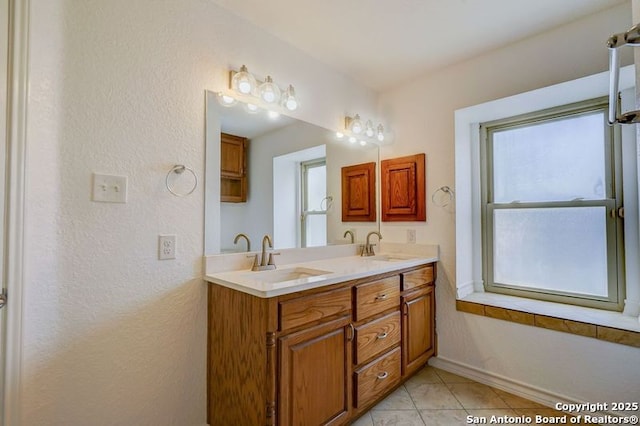 full bathroom with double vanity, a sink, tile patterned flooring, and a wealth of natural light