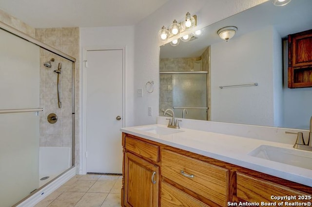 bathroom with double vanity, a sink, tile patterned floors, and a shower stall