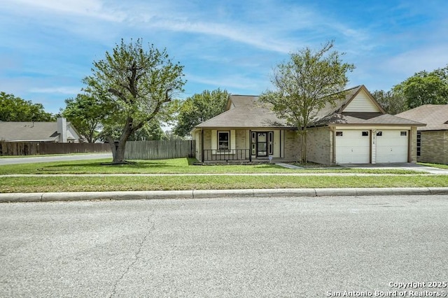 view of front of property featuring fence, an attached garage, a front yard, driveway, and a porch
