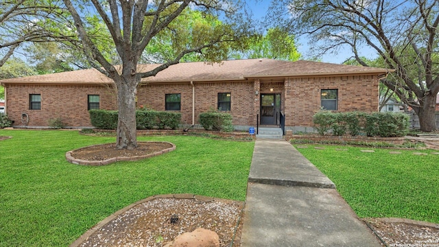 ranch-style house with brick siding, a shingled roof, and a front yard