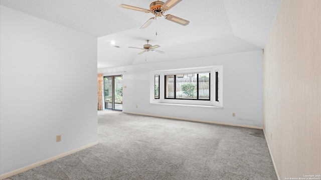 carpeted spare room featuring baseboards, lofted ceiling, and ceiling fan