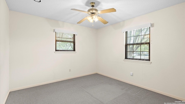 empty room featuring light carpet, baseboards, and ceiling fan
