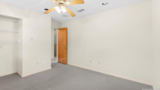 unfurnished bedroom featuring a closet, visible vents, carpet, baseboards, and ceiling fan