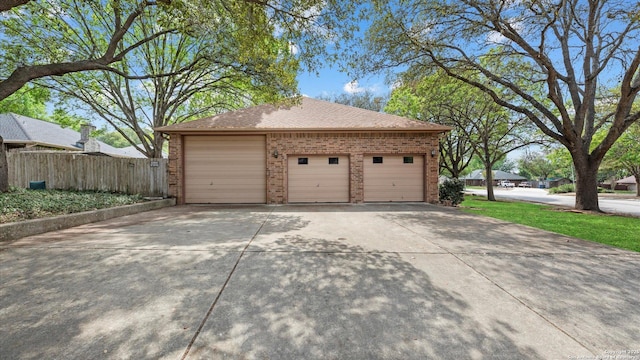 garage with driveway and fence