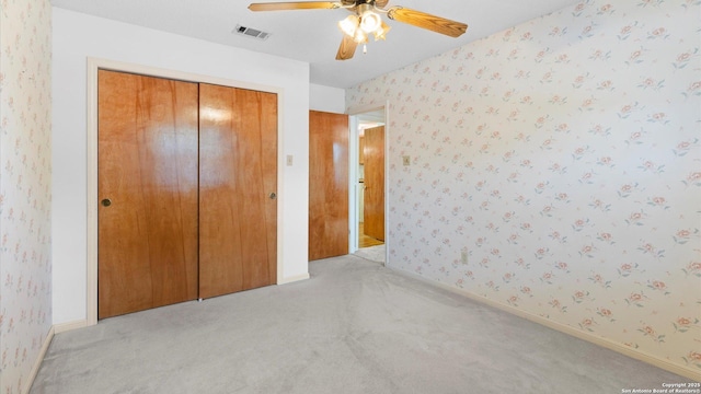 unfurnished bedroom with visible vents, wallpapered walls, and light colored carpet