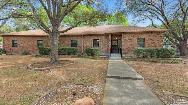 single story home with a shingled roof and brick siding