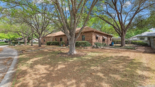 view of front of property with brick siding and fence