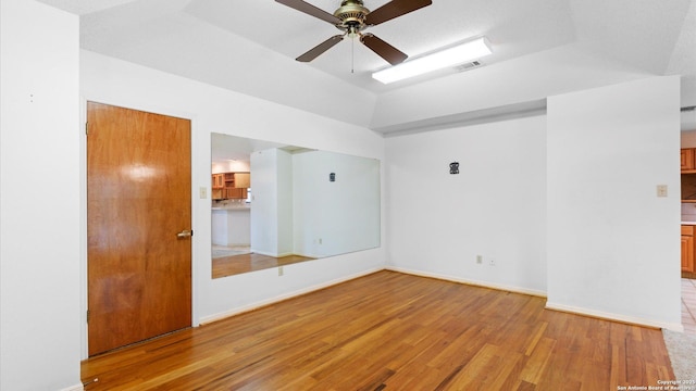 unfurnished room with light wood finished floors, baseboards, ceiling fan, and visible vents