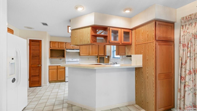 kitchen with light countertops, white appliances, a sink, visible vents, and a peninsula