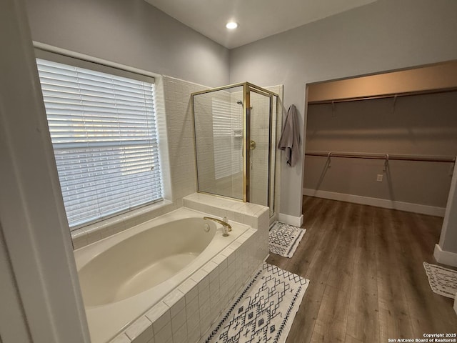 5038 Fawn Lake Dr, San Antonio, TX 78244 - full bathroom featuring a spacious closet, baseboards, a stall shower, a garden tub, and wood finished floors